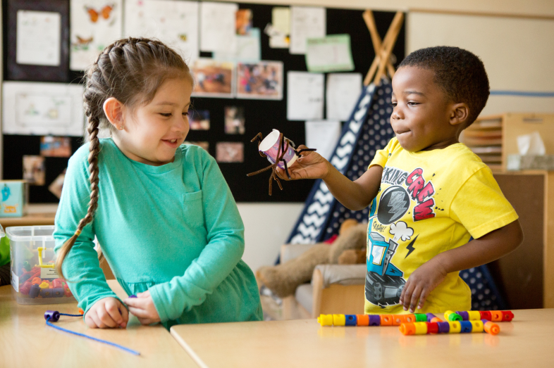 A preschool-aged boy and girl interact.