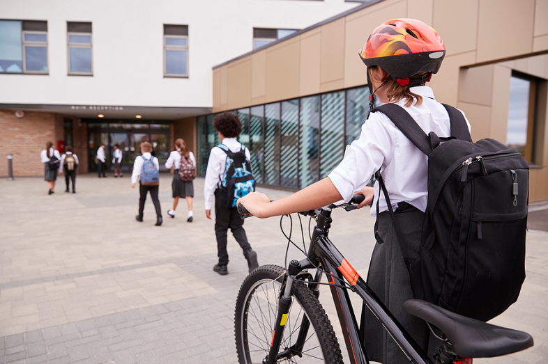 A group of teenagers head toward the front doors of their private school.