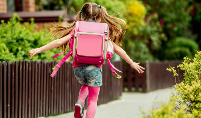 A little girl skips happily outside.