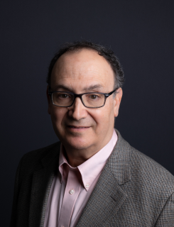 Daniel Golden, a reporter for ProPublica, is pictured in a gray suit and pink dress shirt.