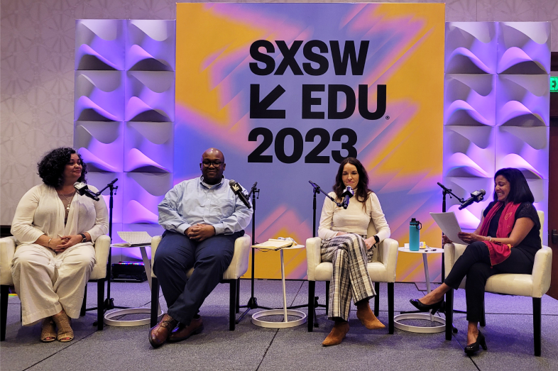 Four panelists sit in chairs on stage during a session at SXSW EDU 2023, where branded signage on the wall behind them is displayed.