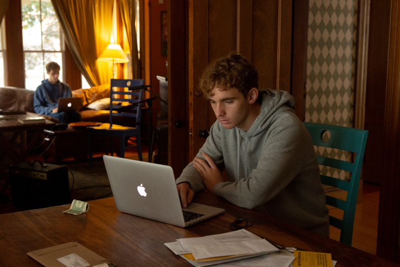 Students stare at their computer screens as they work from home.